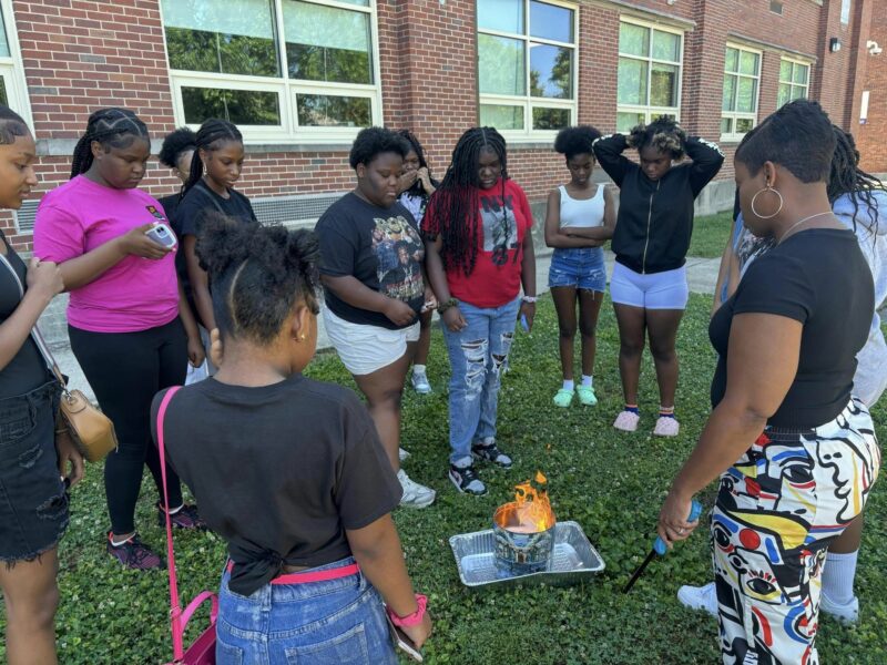 BAYA Corp work pictured here. Girls stand around in collaboration for a group activity.